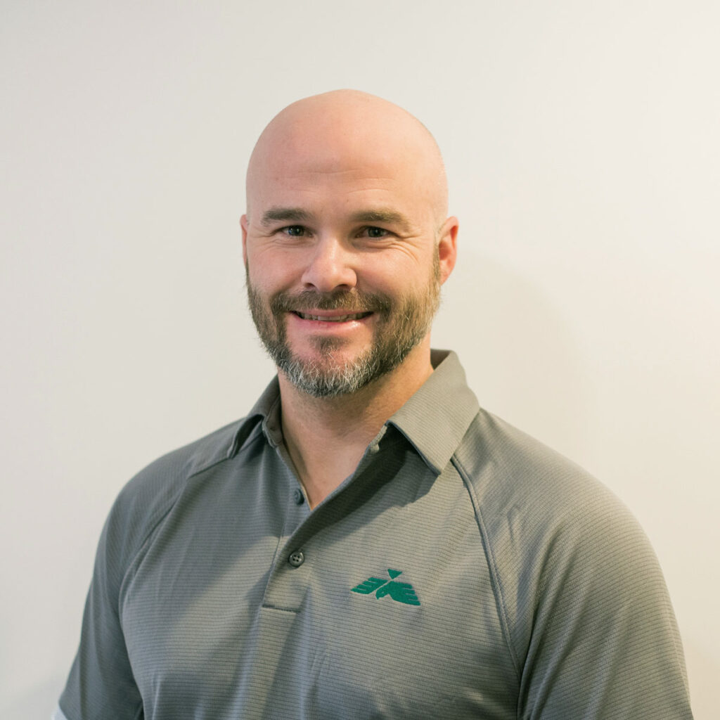 Smiling Falcon Alaska employee wearing company branded polo shirt