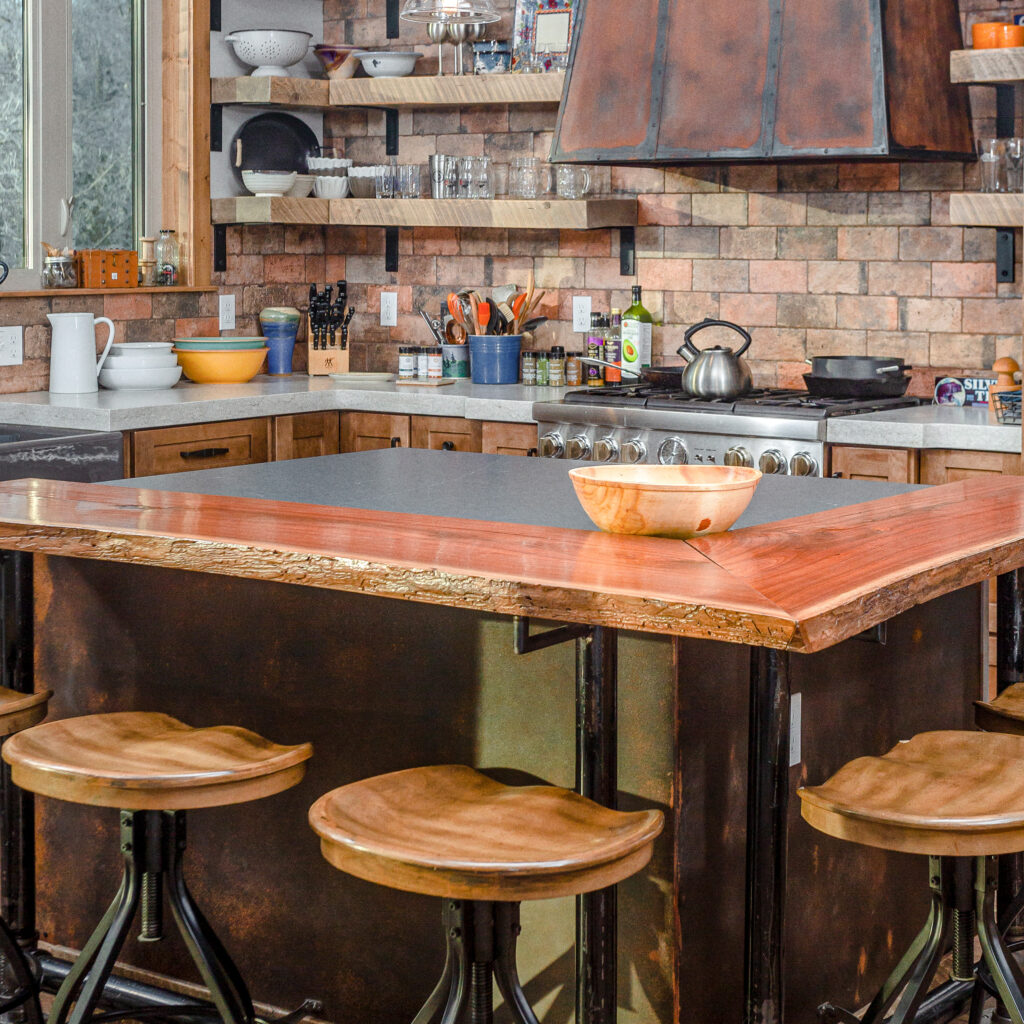 Kitchen with island, wood and metal stools, and stone brick walls