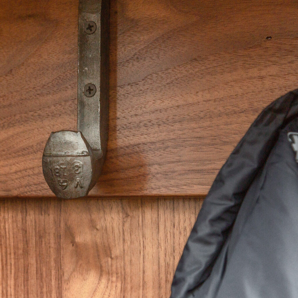 Close-up of metal coat hanger made from reused railroad spike