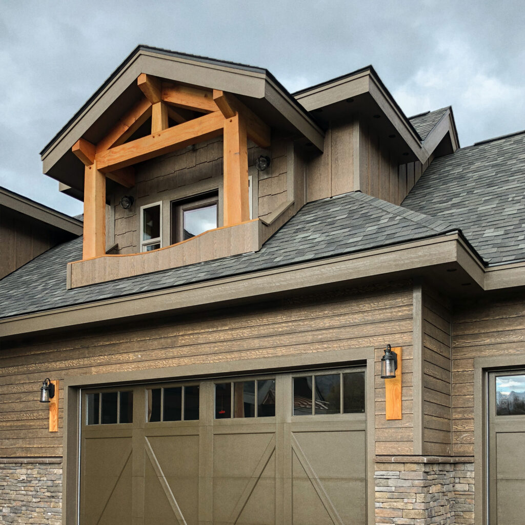 Exterior of a house with a balcony above one side of the garage