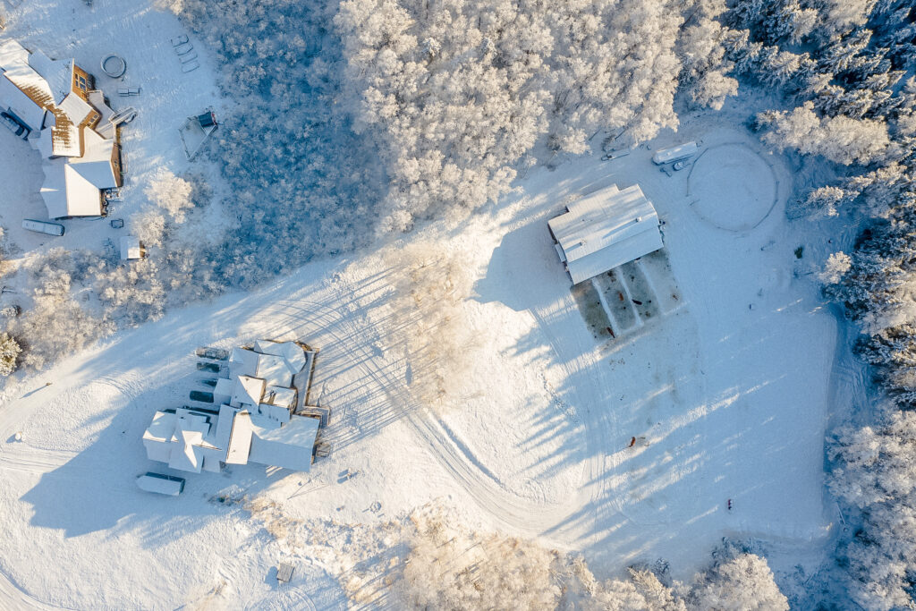 Birdseye view of custom built home in Eagle River, AK with snow