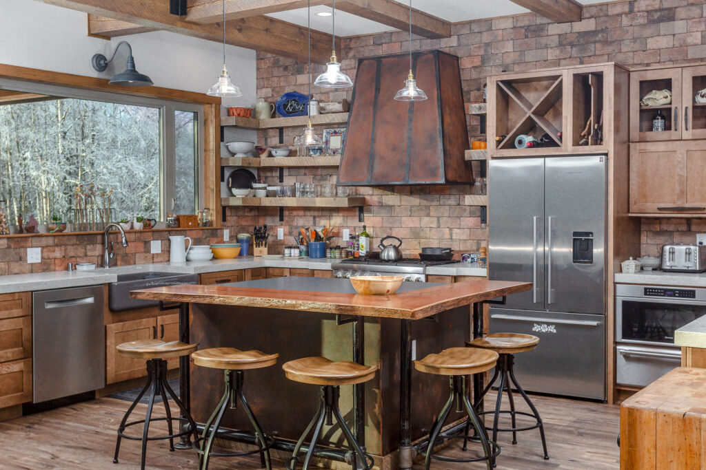 Kitchen with wood island, wood and metal stools, and brown stone brick walls