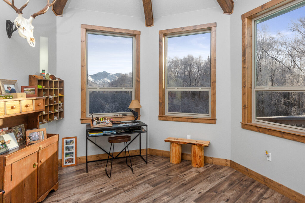 Small room with desk for painting looking out to mountains outside the windows