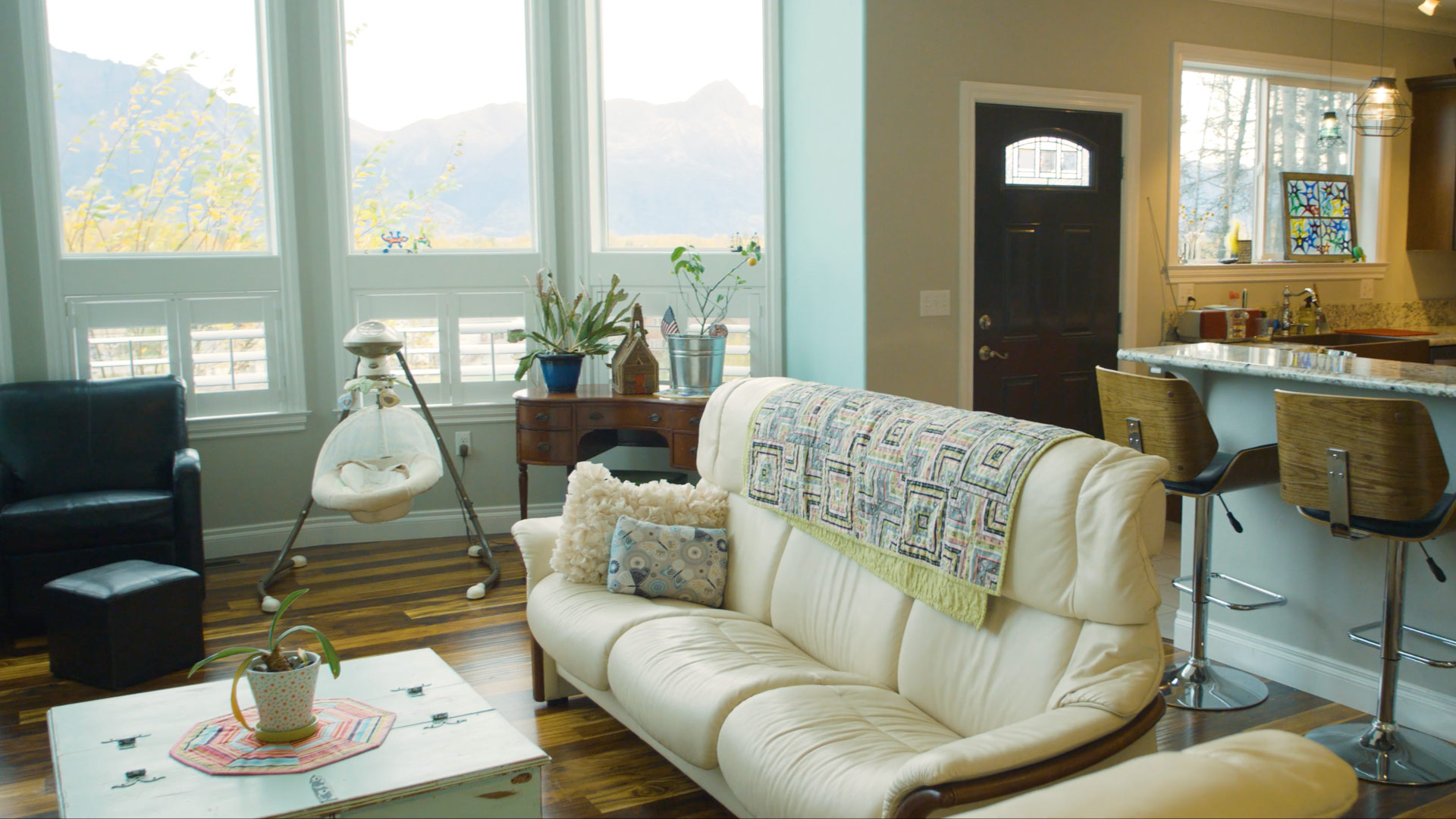 Living room of a house with furniture and large windows looking out to mountains