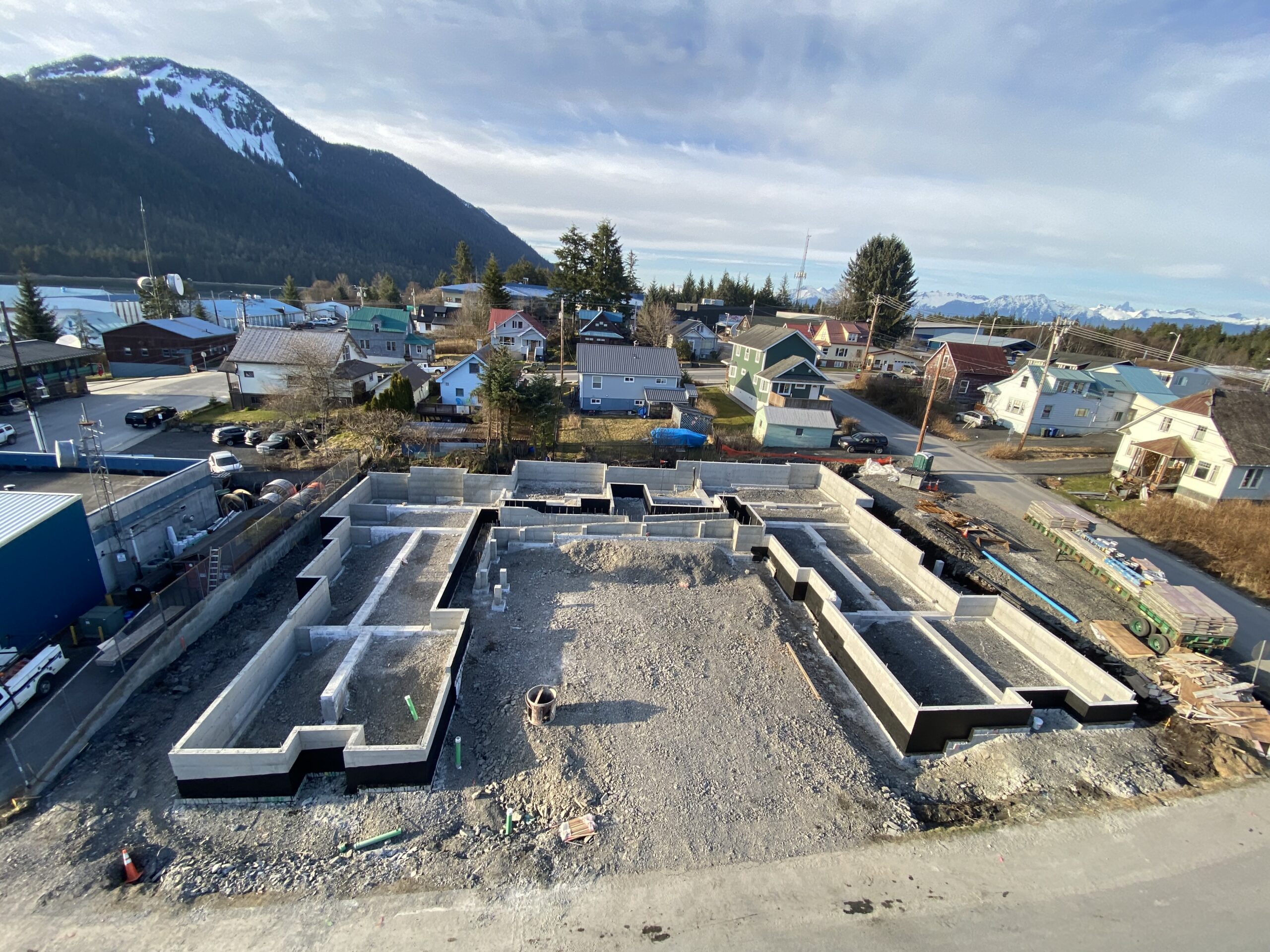 Concrete foundation of a new building in a construction lot with mountain in the background
