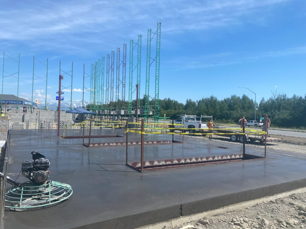 Freshly poured concrete floor being dried with a large fan outside