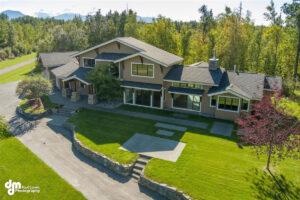 High angle of a new, large house with woods behind it