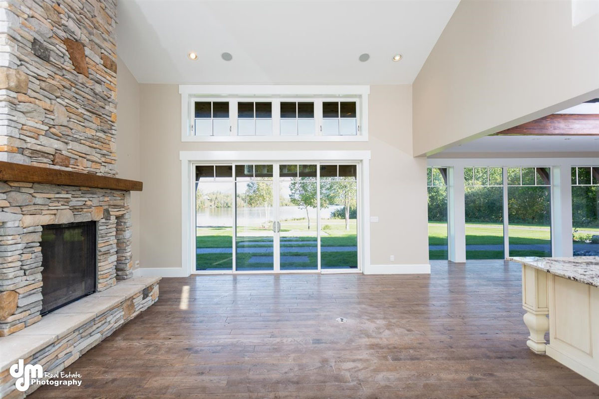 Living space of custom built Alaskan home with fireplace & sliding glass doors