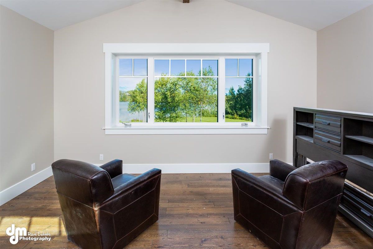 Two leather chairs inside of a custom built home in front of large window