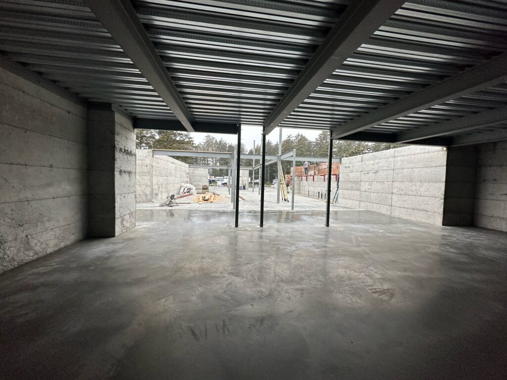 Inside of building under construction with newly poured concrete foundation